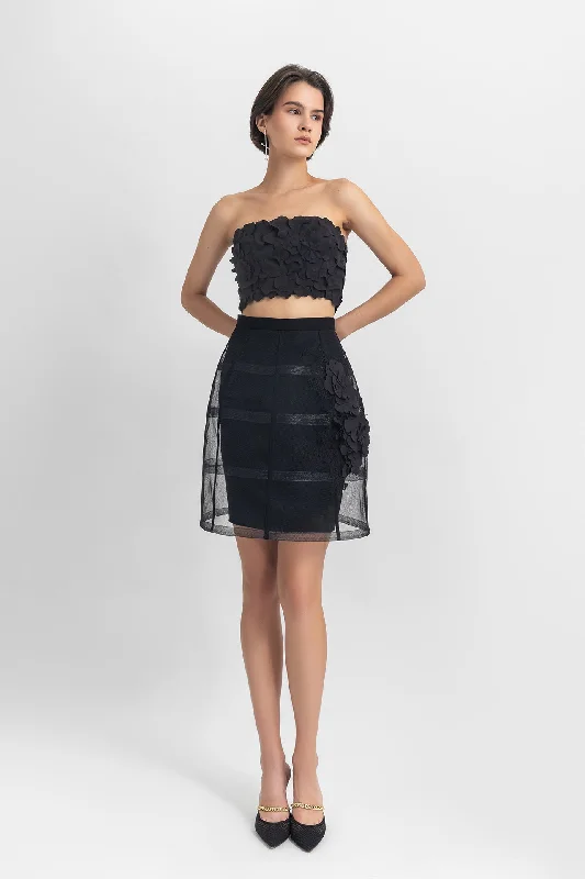 Strapless cropped-top with laser-cut details, paired with a cage-like skirt with flower details
 on the side. low waist skirt